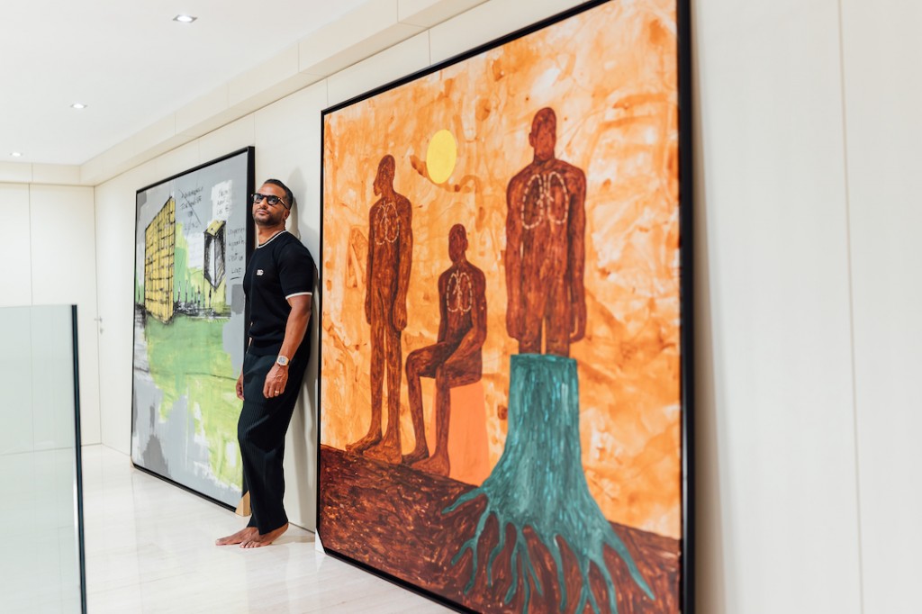 Ivanilson in front of works by Binelde Hyrcan, Hypnosis, 2020 and Beningo, Untitled, 2022. Photo: Hodias Jamba. Courtesy of Ivanilson Machado